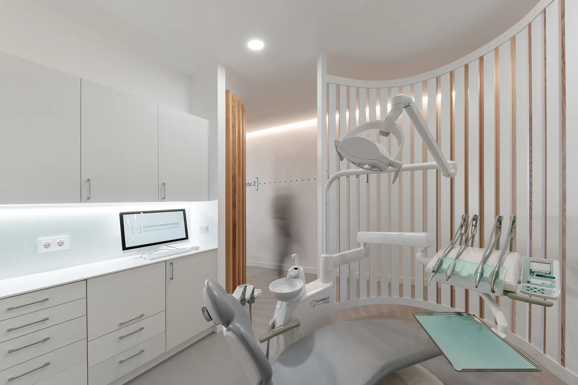 Gabinete de la clínica con sillón dental y celosía de madera que da intimidad al paciente