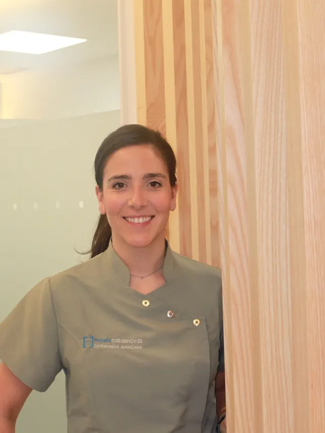 Profesional de Sabela Casasnovas Ortodoncia Avanzada sonriendo con el uniforme de la clínica